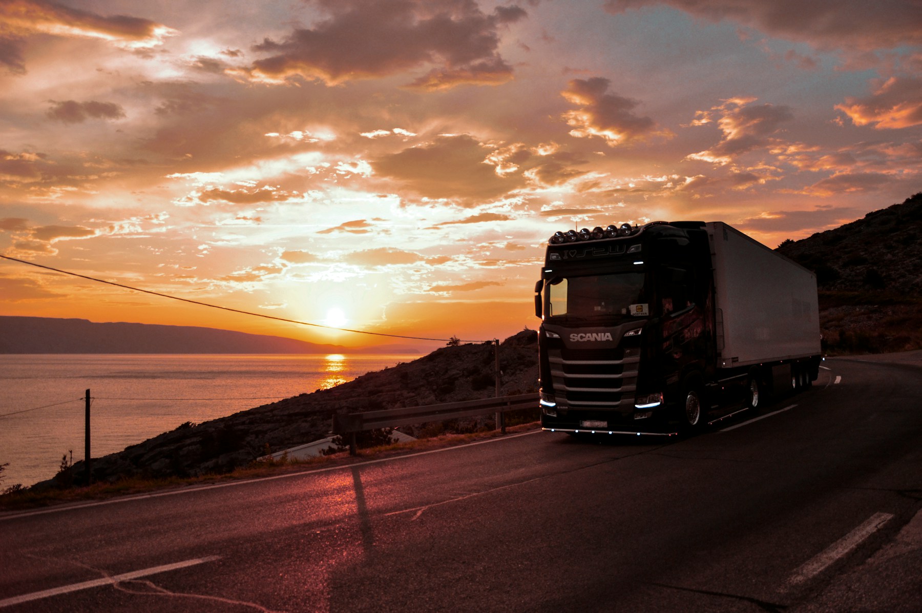 European articulated freight truck travelling along a coastal road